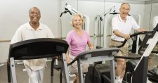 Is Sitting Too Much Bad for Your Brain? Picture of an elderly black male, an elderly caucasian female and an elderly caucasian male all walking on treadmills.