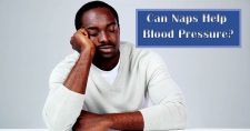 Naps and Blood Pressure. Picture of a black man sitting at a table resting his head on his hand while leaning on the table.